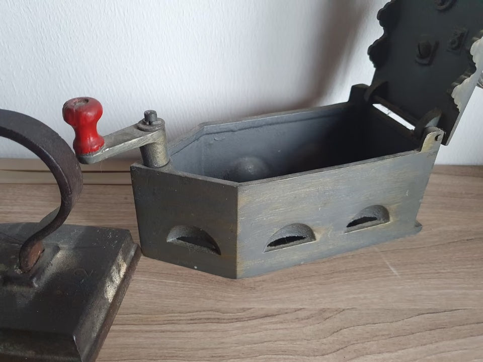 Drei alte Bügeleisen als Dekorationsset – Geöffnetes Kohlebügeleisen mit rotem Holzgriff