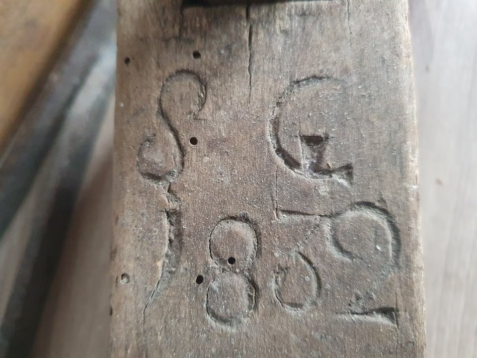Geschnitzte Initialen und Jahreszahl 1832 auf einem Holzhobel