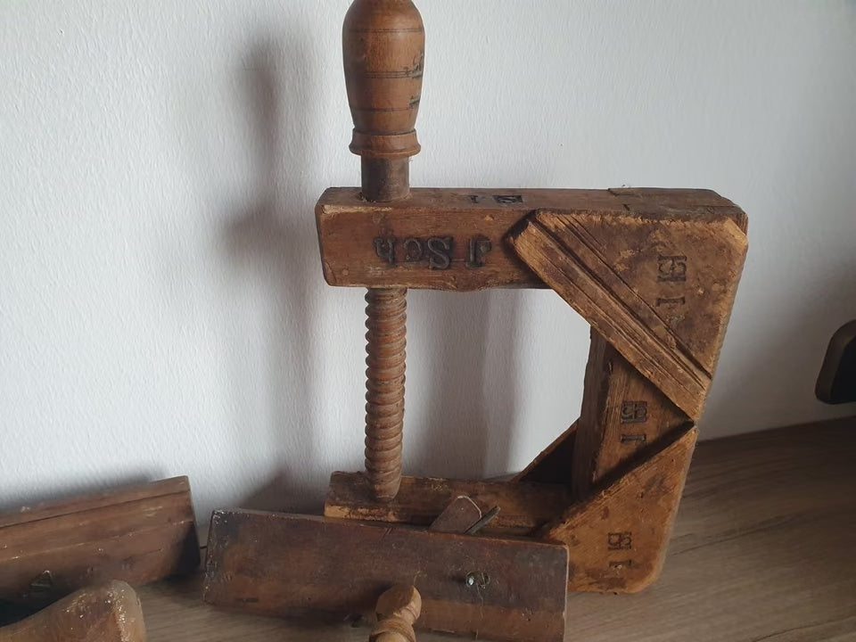 Alte Holzschraubzwinge mit Holzgewinde und eingeschnittenen Zeichen