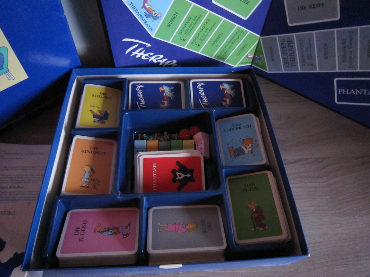 Vollständiges Therapy-Spielmaterial mit Karten, Couch-Spielfiguren, Stiften und Würfeln